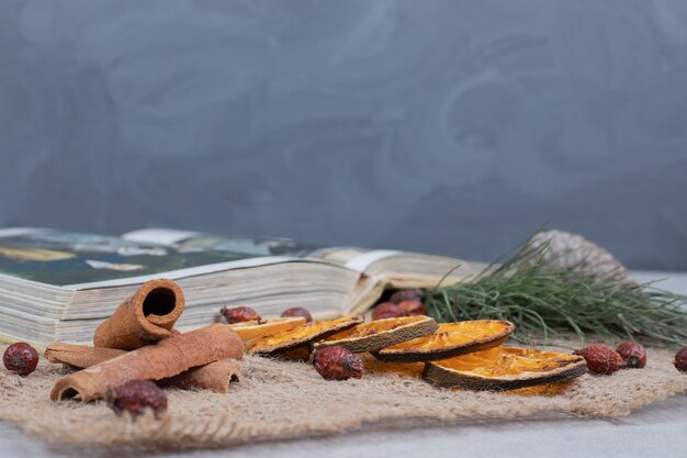 Tranches de cannelle, canneberge et mandarine séchée sur toile de jute. Photo de haute qualité
