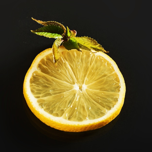 Photo gratuite tranches de citron juteuses fraîches sur fond noir.