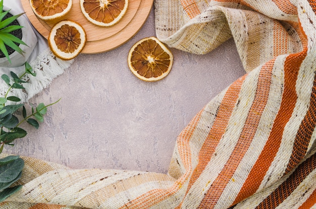 Photo gratuite tranches de citron séchées avec des rayures textiles sur fond de béton