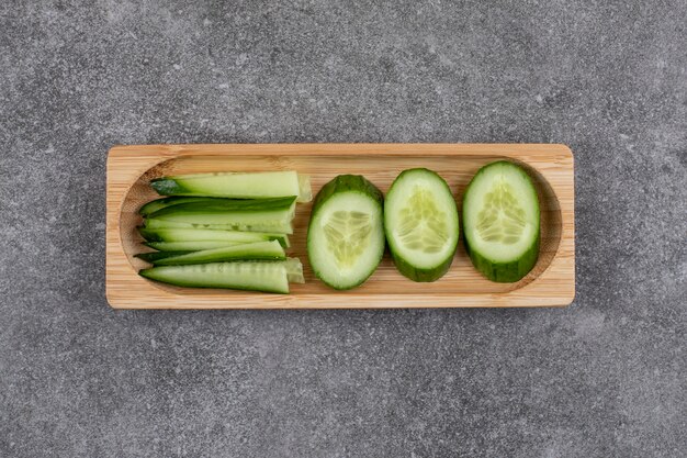 Tranches de concombre bio sur planche de bois