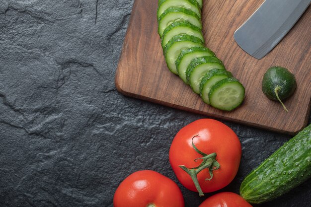 Tranches de concombre et de tomate sur fond noir. Photo de haute qualité