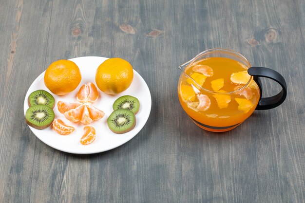 Tranches de divers fruits avec un bocal en verre de jus