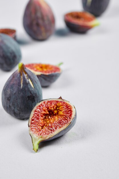 Tranches de figues entières et de figues sur blanc.