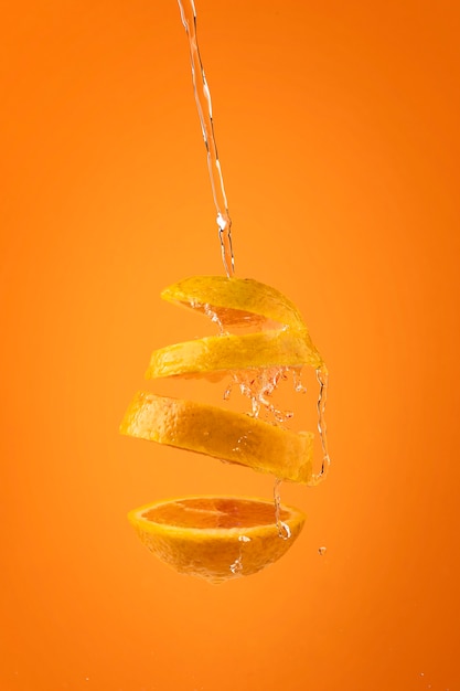 Photo gratuite tranches flottantes orange avec fond clair