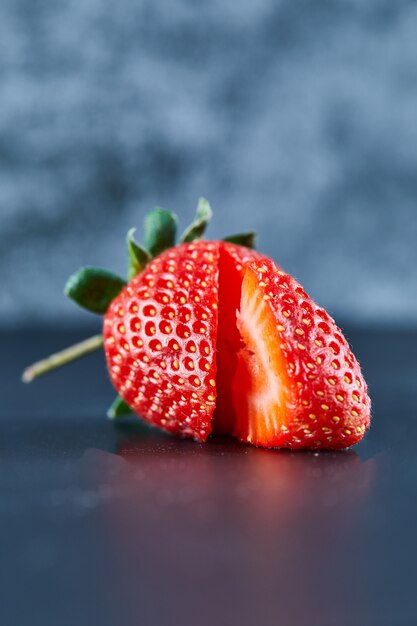 Tranches de fraises rouges fraîches sur une surface sombre