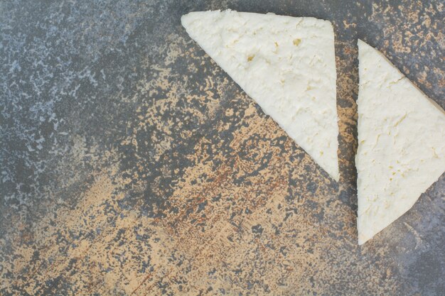 Tranches de fromage blanc sur marbre.