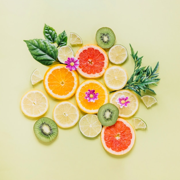 Tranches de fruits décorées de feuilles et de fleurs