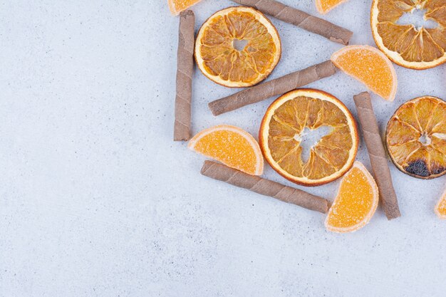 Tranches de fruits secs, marmelades et bâtonnets sur une surface en marbre.