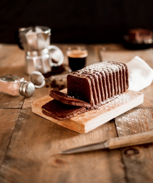 Tranches de gâteau au chocolat sur une planche à découper en bois sur la table