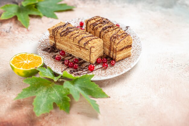 Tranches de gâteau avec glaçage choco et fruits rouges sur fond gris