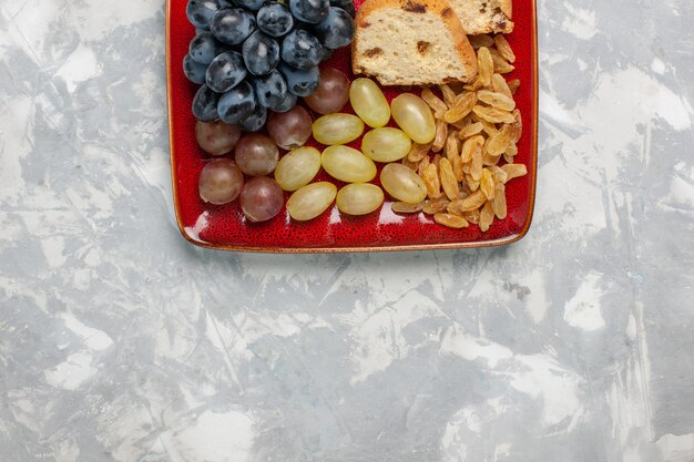 Tranches de gâteau vue de dessus avec des raisins et des raisins secs à l'intérieur de la plaque rouge sur la surface blanche