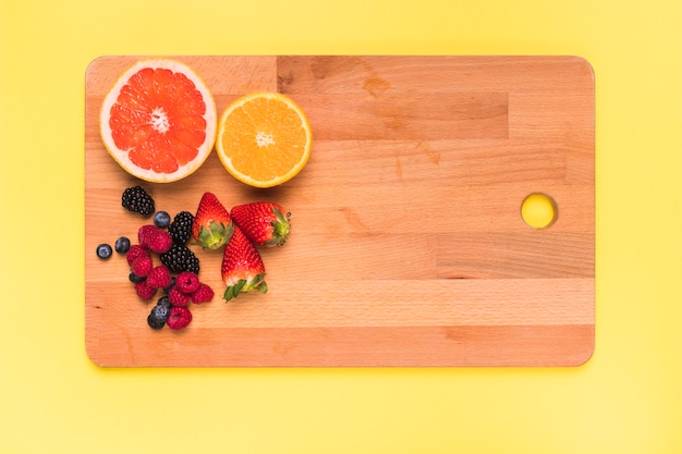 Tranches de jus d&#39;orange citron orange fraise mûre framboise et cassis sur une planche à découper