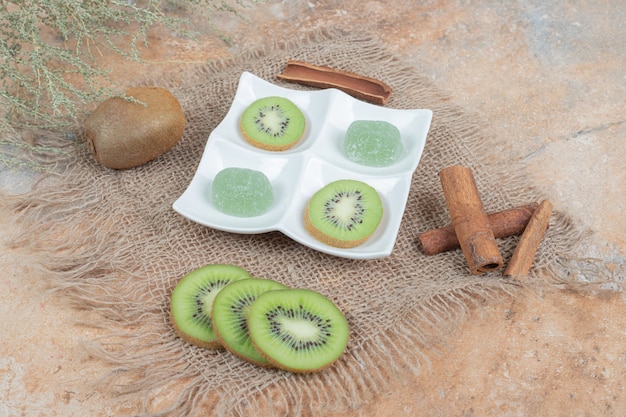 Tranches de kiwi, cannelle et marmelade sur toile de jute.