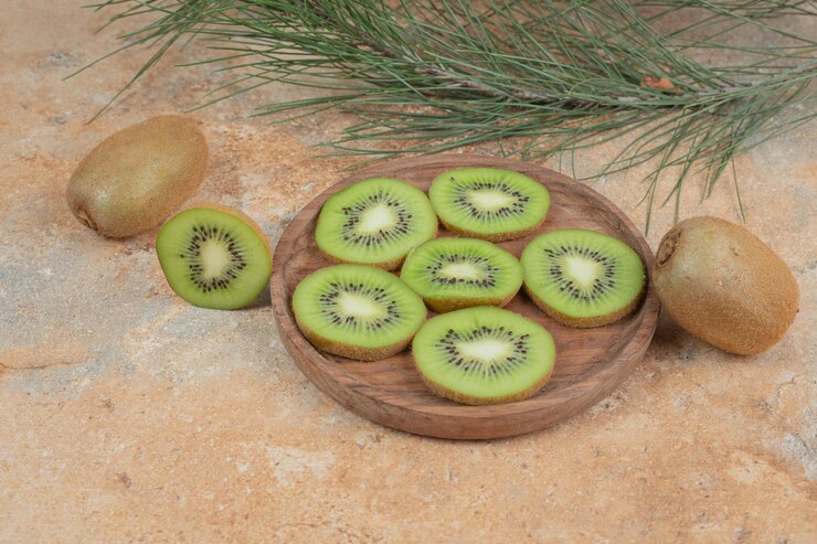Photo gratuit tranches de kiwi mûr sur plaque en bois.