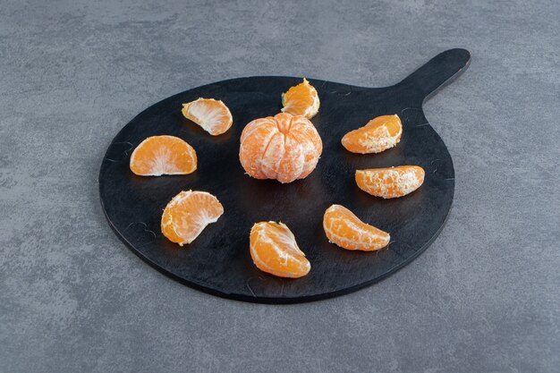 Tranches de mandarine savoureuses sur une planche à découper.