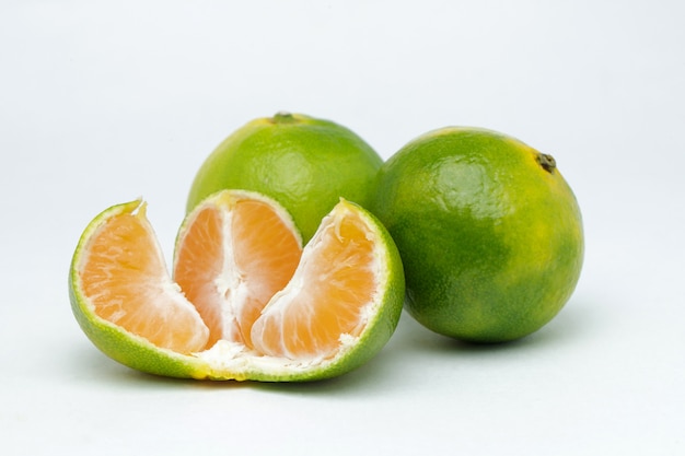 Tranches de mandarine sur une surface blanche