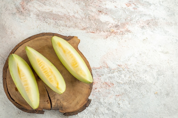 Tranches de melon sur plaque de bois dans le coin droit du marbre