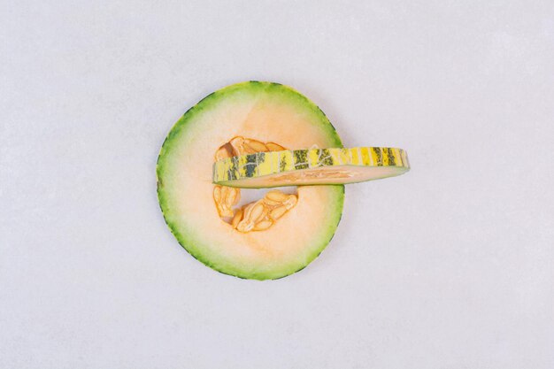 Tranches de melon vert sur tableau blanc.