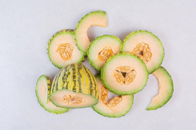 Tranches de melon vert sur tableau blanc.