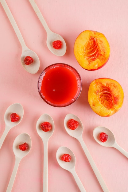 Tranches de nectarine avec cerise séchée, vue de dessus de jus sur une table rose