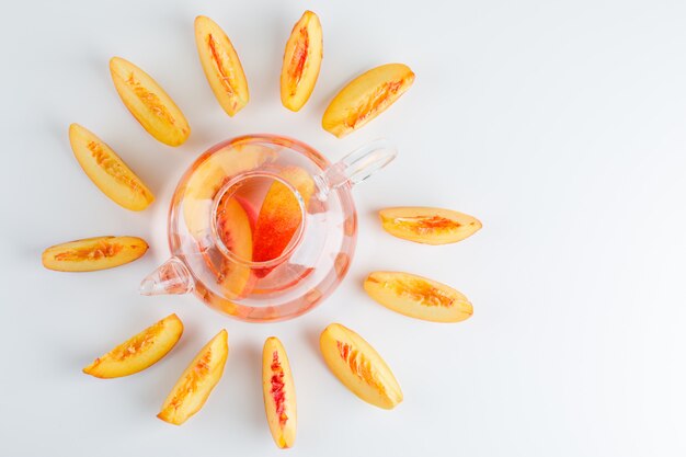 Tranches de nectarine avec vue de dessus de boisson d'été sur une surface blanche