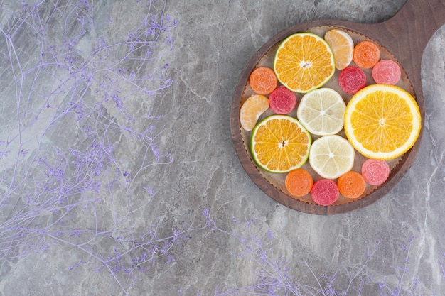 Tranches d'orange, citron, mandarine et bonbons à bord.