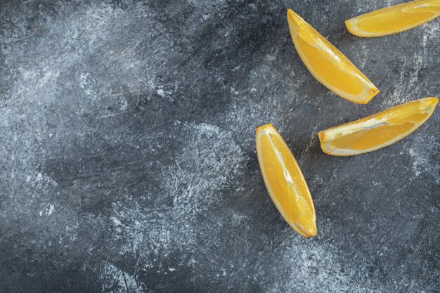 Tranches d'orange fraîche sur table en marbre.