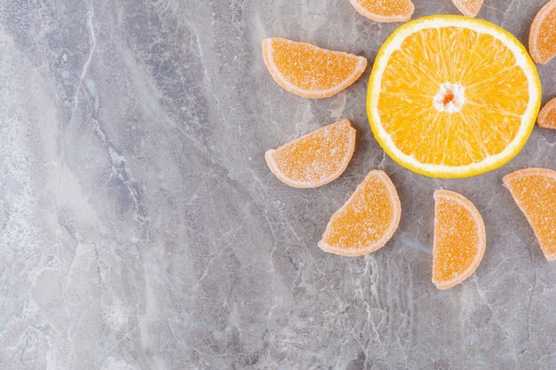 Tranches d'orange fraîches avec des marmelades sucrées sur fond de marbre.