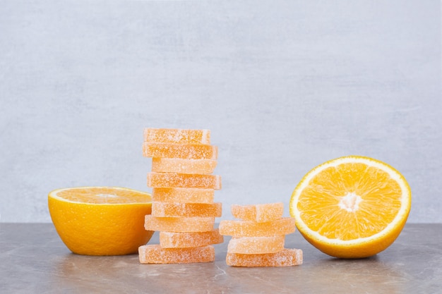Tranches d'orange fraîches avec des marmelades sucrées sur fond de marbre.