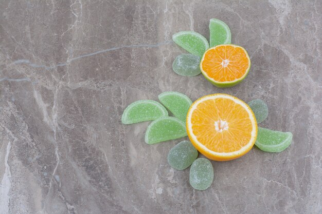 Tranches d'orange fraîches avec des marmelades sucrées sur fond de marbre.