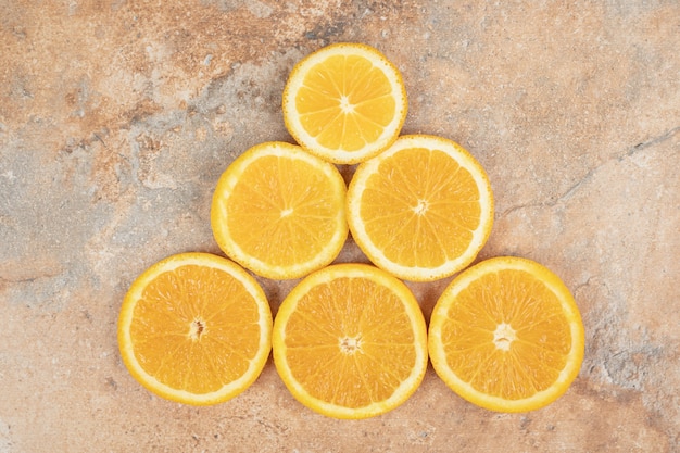 Tranches d'orange juteuses sur une surface en marbre.