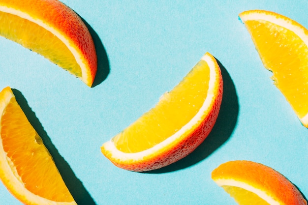 Tranches d&#39;orange mûre avec une peau brillante sur une surface turquoise