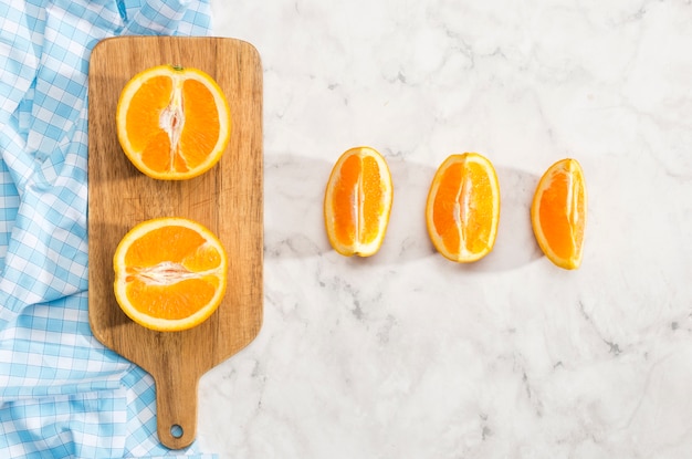 Photo gratuite tranches d'orange sur une planche à découper en bois