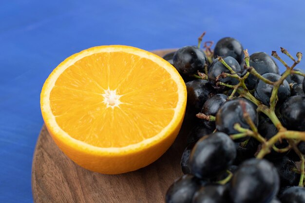 Tranches d'orange avec des raisins sur planche de bois