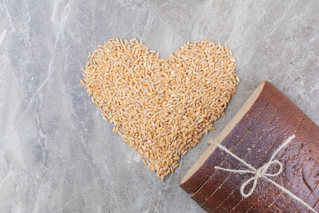 Tranches de pain brun avec des grains d'avoine sur une surface en marbre