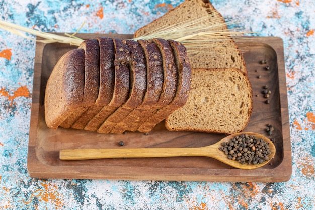 Tranches de pain frais sur une planche en bois