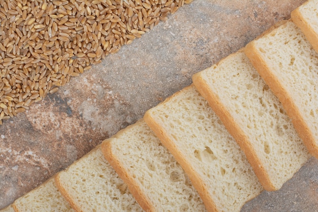 Tranches de pain grillé blanc avec de l'orge sur fond de marbre