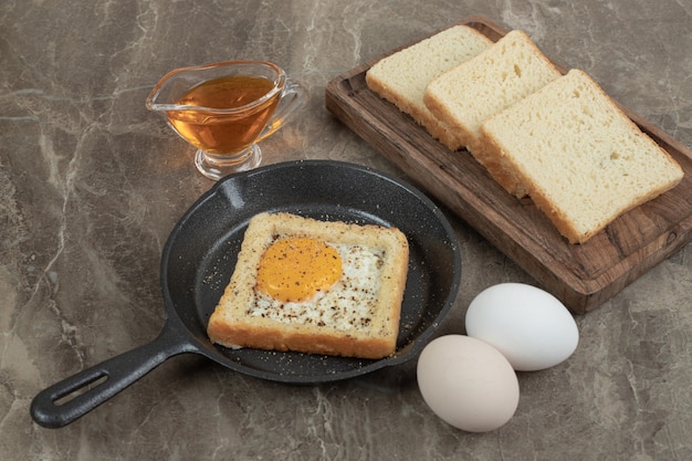 Tranches de pain, œufs et huile sur table en marbre. Photo de haute qualité