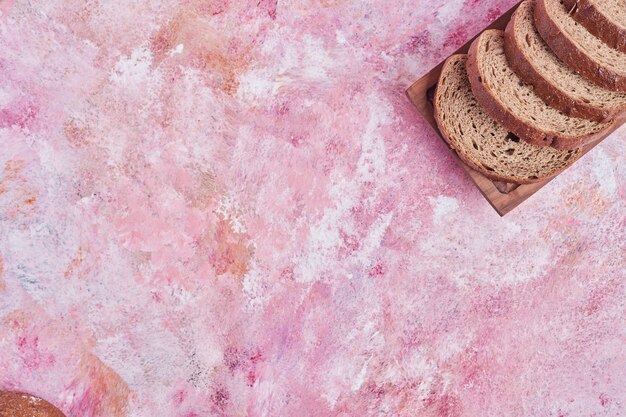 Tranches de pain sur une planche de bois.