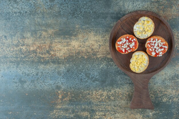 Tranches de pains blancs frais avec de la confiture sur planche de bois