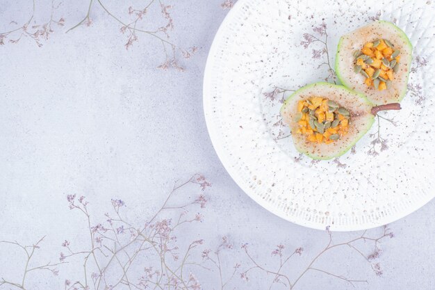 Tranches de poire cuites aux herbes et épices dans une assiette blanche.