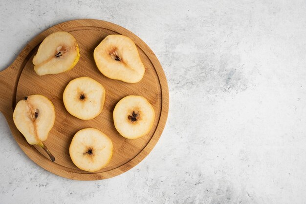 Tranches de poire sur une planche de bois.