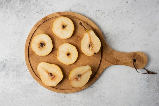 Tranches de poire sur un plateau en bois.