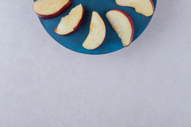 Tranches de pomme sur une assiette sur une table en marbre.