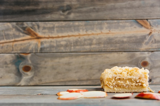 Tranches de pomme et pâtisserie sur une surface en bois