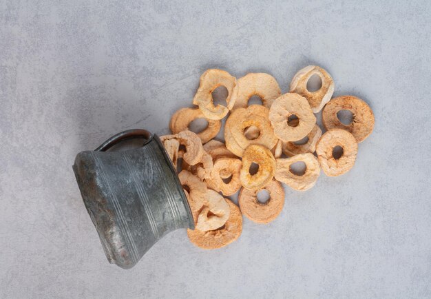 Tranches de pommes séchées dans un pot métallique.