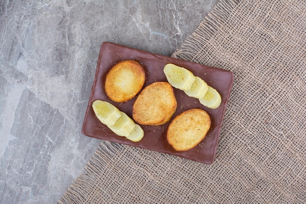 Tranches de pommes de terre frites et concombres marinés sur assiette. Photo de haute qualité