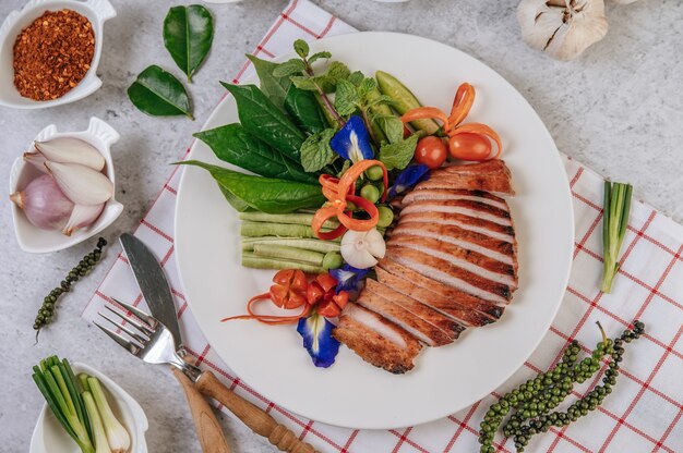 Tranches de porc frit au citron, oignon, oignon rouge, tomate, haricot long, pois papillon fleur et menthe.