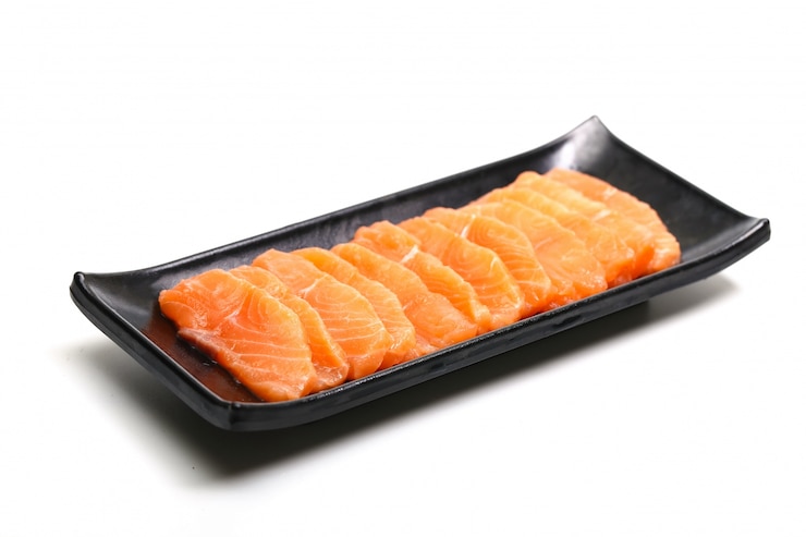 Photo gratuit tranches de saumon en plaque noire sur fond blanc