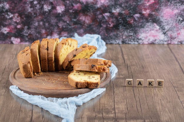 Tranches de tarte sucrée isolées sur une planche de bois.